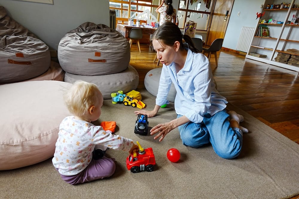 Audrey Bergner kneels on the carpet playing with toy vehicles beside Aurelia Jeffery inside the children’s room at Llao Llao Hotel in Bariloche, Río Negro, Patagonia, Argentina.