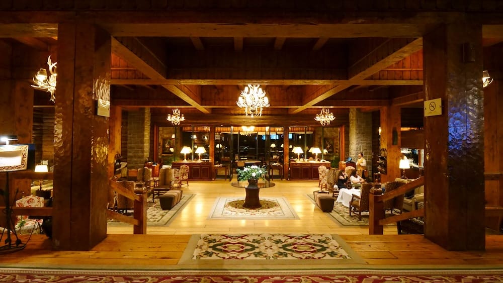 Main Hall at Night, Llao Llao Hotel, Bariloche, Río Negro, Argentine Patagonia The main hall at Llao Llao Hotel glows in the evening with antler chandeliers, log-beam ceilings, and seating areas beneath timber columns, Bariloche, Río Negro, Argentine Patagonia.