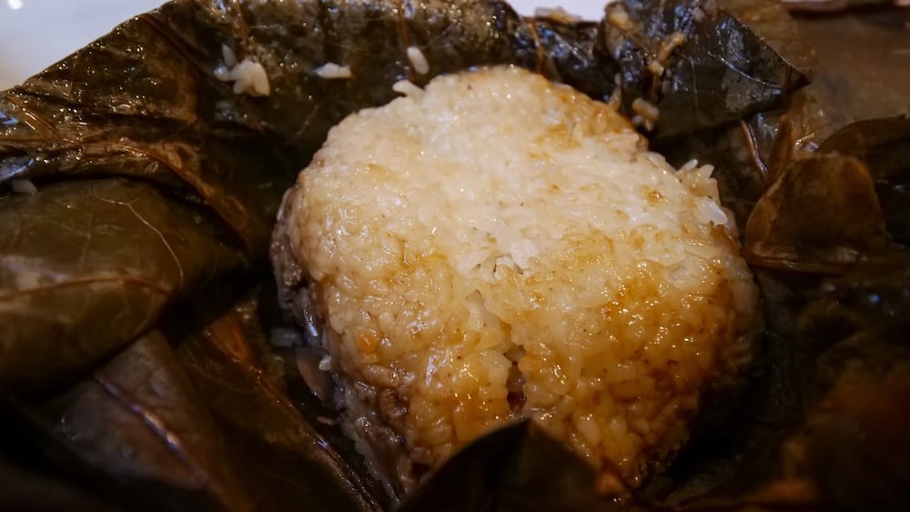 Lo Mai Gai Lotus-Leaf Sticky Rice at Silver Dragon Restaurant, Chinatown, Calgary, Alberta, Canada Steamed glutinous sticky rice, known as lo mai gai, opened out of its lotus leaf wrapping at Silver Dragon Restaurant in Chinatown, Calgary, Alberta, Canada.