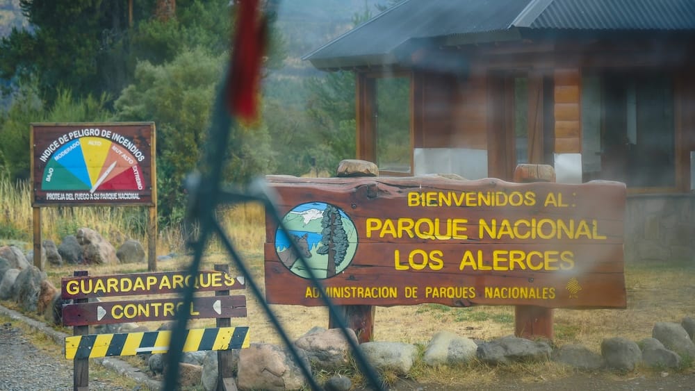 Los Alerces National Park Entrance Sign from a Bus Near Esquel Patagonia Travel Time Guide Los Alerces National Park entrance sign seen from a bus near Esquel, Argentina, showing how Patagonia park days depend on shuttle timing, return seats, entry stops and slower real-world travel times.