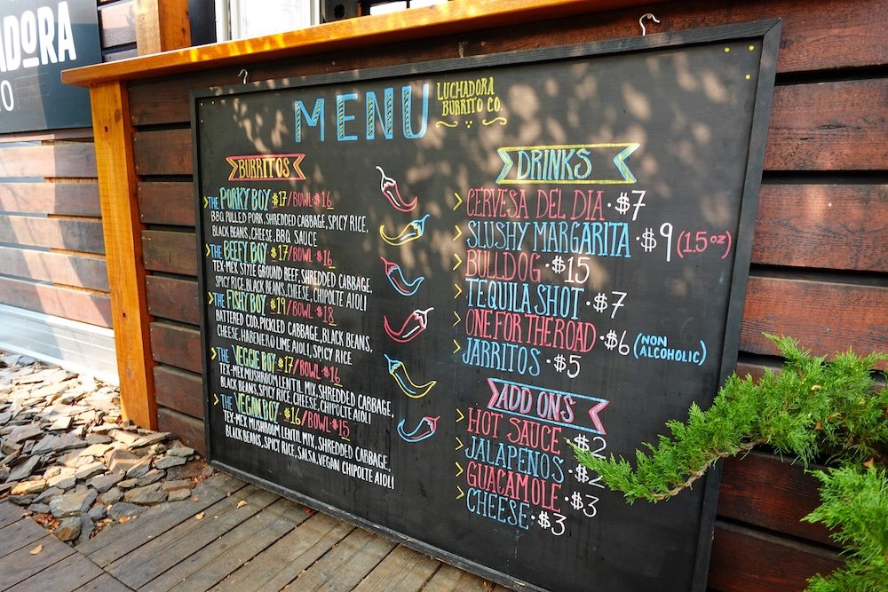 Luchadoro Burrito Co menu in Fernie, British Columbia displayed on a colorful chalkboard, highlighting burritos, drinks, and add-ons that make this casual patio spot a fun and filling stop on a two-day Fernie itinerary.