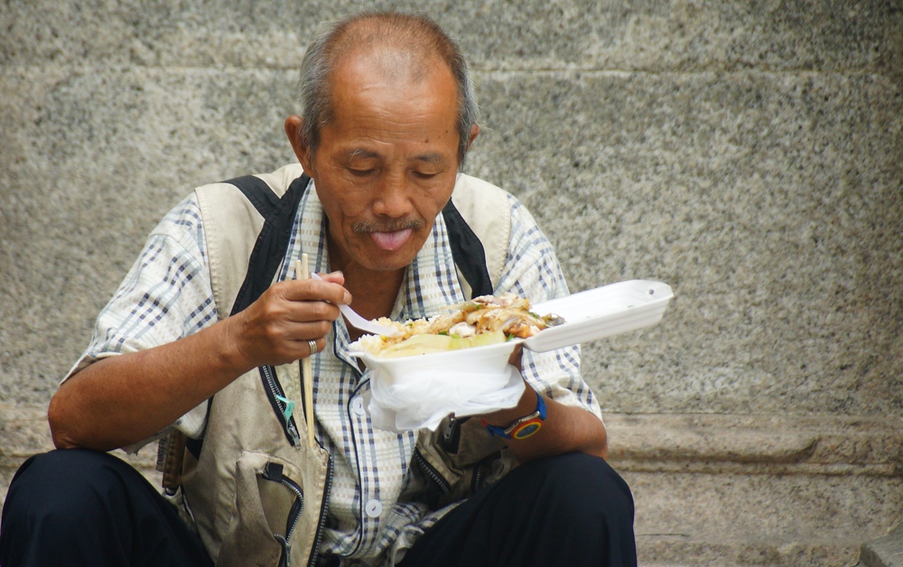 Man sitting down to eat Macanese cuisine