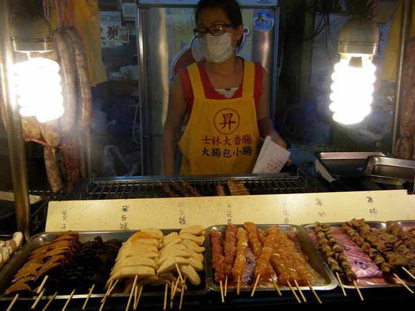Market vendor in Taiwan serving street food such as skewered meat
