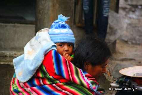 Baby on back of mother in markets of La Paz, Bolivia