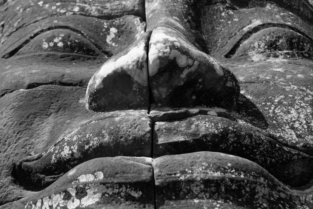 Massive stone face smile up close at Bayon, Angkor Thom.