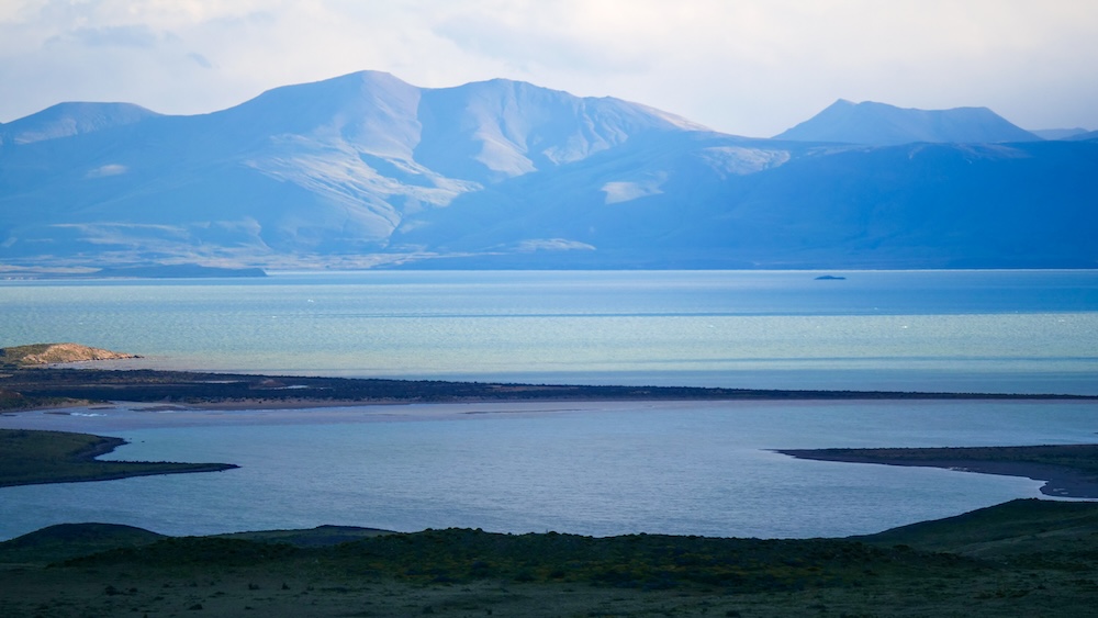 Zoomed view of Lake Viedma from Mirador de las Águilas A zoomed-in view of Lake Viedma from the Mirador de las Águilas hike in El Chaltén, where layered blue water and distant Patagonian mountains create a striking compressed landscape.