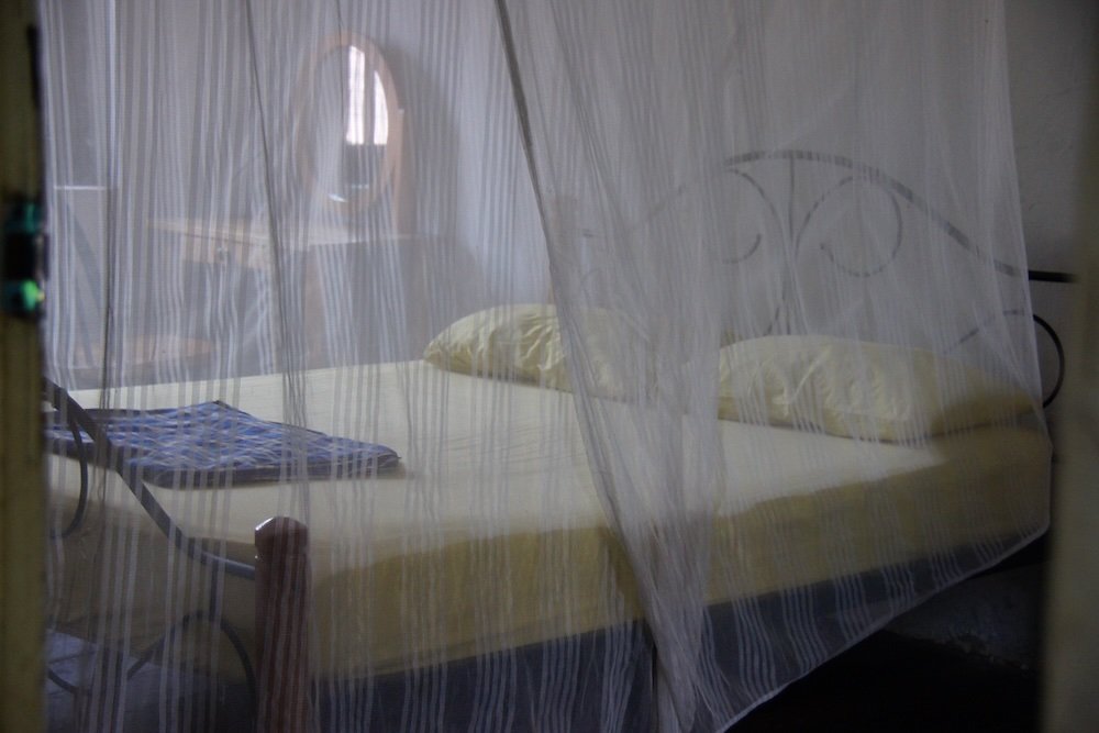 Mosquito net covering bed at a guesthouse in Melaka, Malaysia 