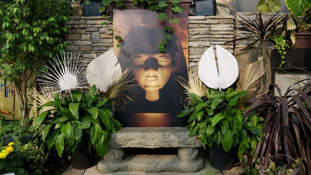 Feature Pyramid themed display, Muttart Conservatory, Edmonton, Alberta, Canada. An Ancient Egypt-themed display in the Feature Pyramid at the Muttart Conservatory in Edmonton, Alberta, Canada, featuring a large pharaoh backdrop surrounded by palm fronds and stonework.