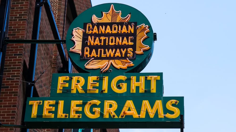 Cartel de neón de Canadian National Railways en el Neon Sign Museum, 104 Street, Edmonton, Alberta, Canadá Cartel de neón de Canadian National Railways con las palabras "Freight" y "Telegrams" y un diseño de hoja de arce, montado sobre una pared de ladrillo contra un cielo celeste en el Neon Sign Museum, en el centro de Edmonton, Alberta, Canadá.