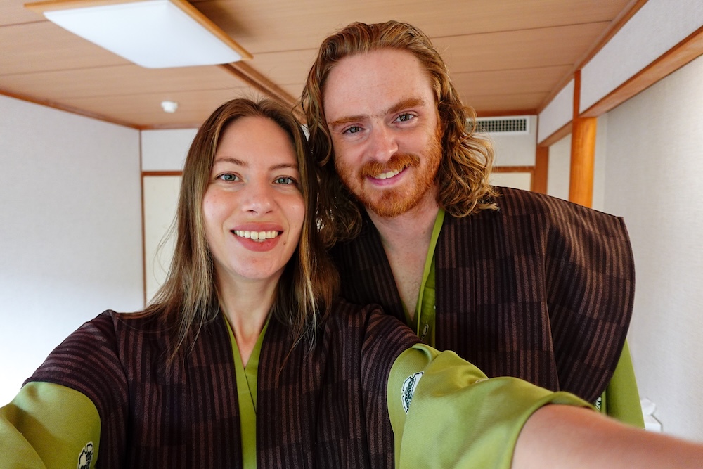 Noboribetsu, Hokkaido, Japan cultural experience, with Nomadic Samuel and Audrey Bergner wearing traditional yukata robes inside a Japanese ryokan room, smiling during an immersive onsen visit in northern Japan.