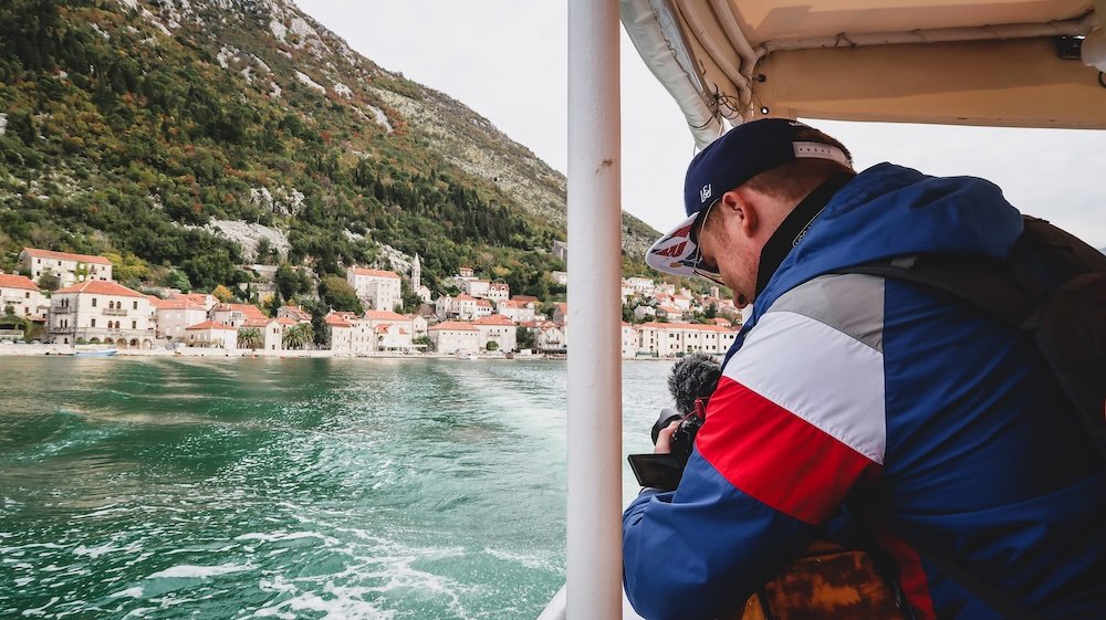 Nomadic Samuel capturing the scenic views on a boat tour in Perast, Montenegro 