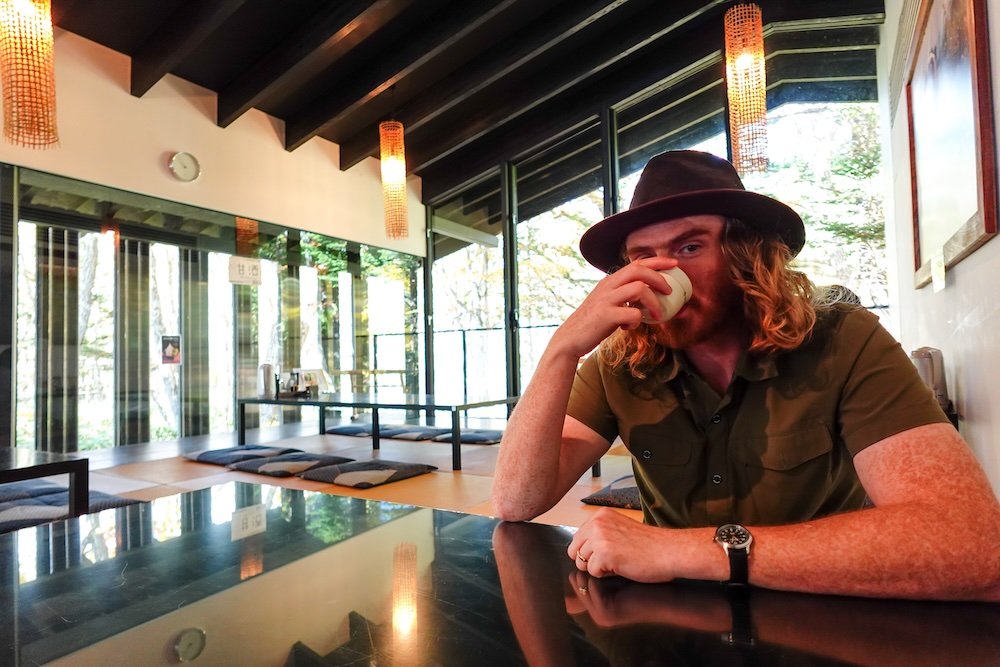 Nomadic Samuel drinking Japanese tea while waiting for Soba Lunch at Okusha-mae Naosuke on a day trip from Nagano city, Japan