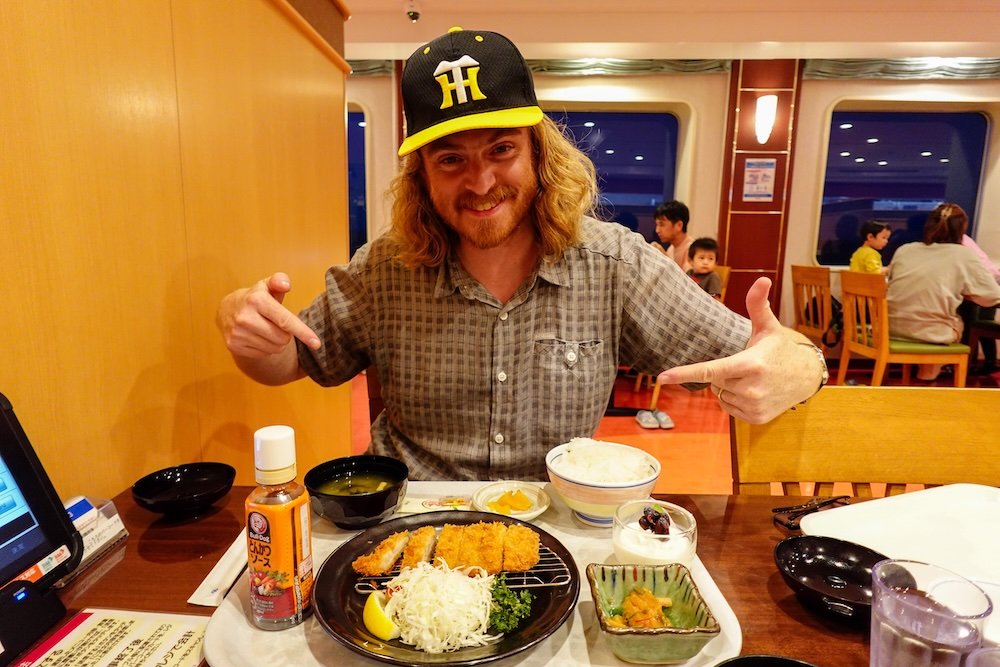 Nomadic Samuel eating an epic Japanese meal on the ferry bound for Niigata