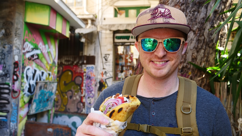 Nomadic Samuel eating delicious Greek street food in Athens, Greece