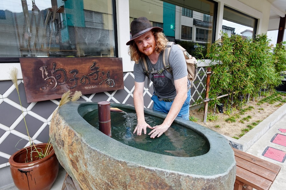 Nomadic Samuel enjoying a hand bath in Yuzawa, Japan