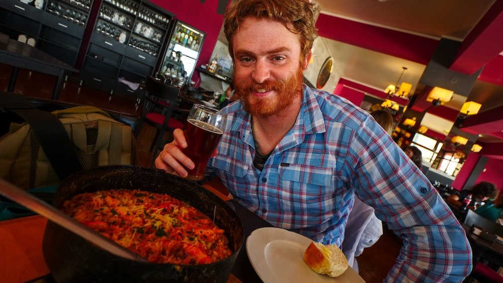 Nomadic Samuel enjoying a beer and crab dish in Ushuaia, Argentina 