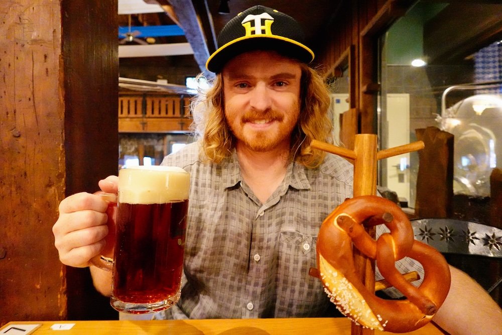 Nomadic Samuel enjoying a beer and pretzel in Otaru, Japan 