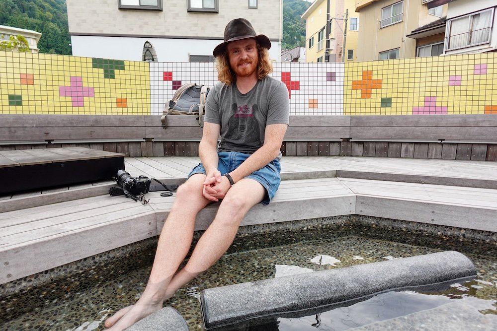 Nomadic Samuel enjoying a natural foot bath in Yuzawa, Japan