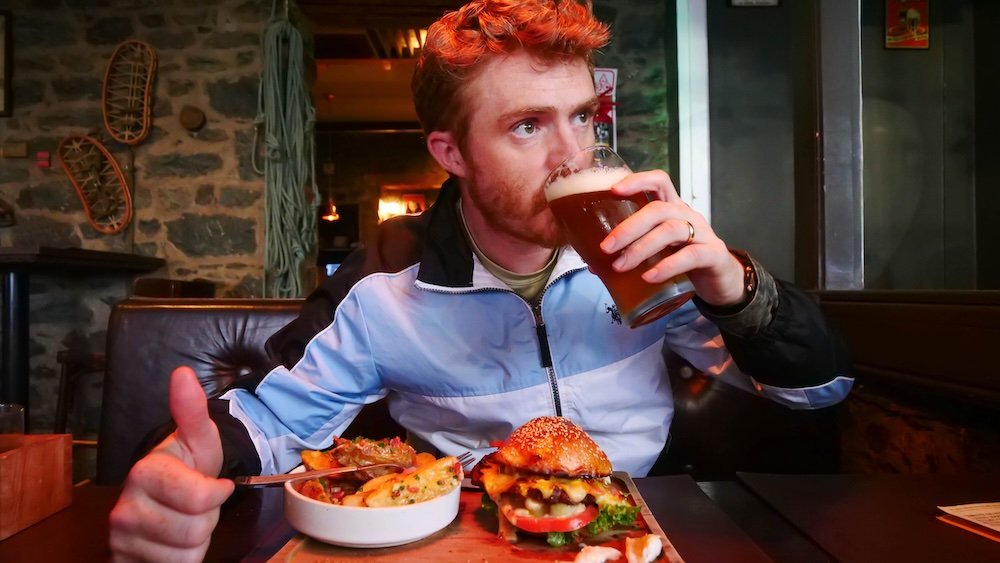 Nomadic Samuel enjoying beer and burgers and fries in Bariloche, Argentina 