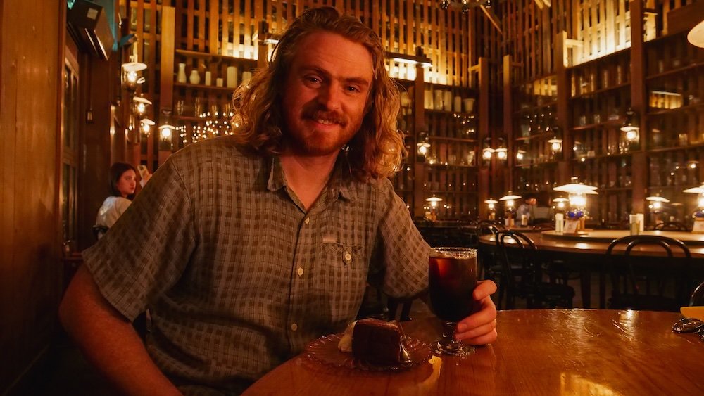 Nomadic Samuel enjoying cake and a drink in Otaru, Japan 