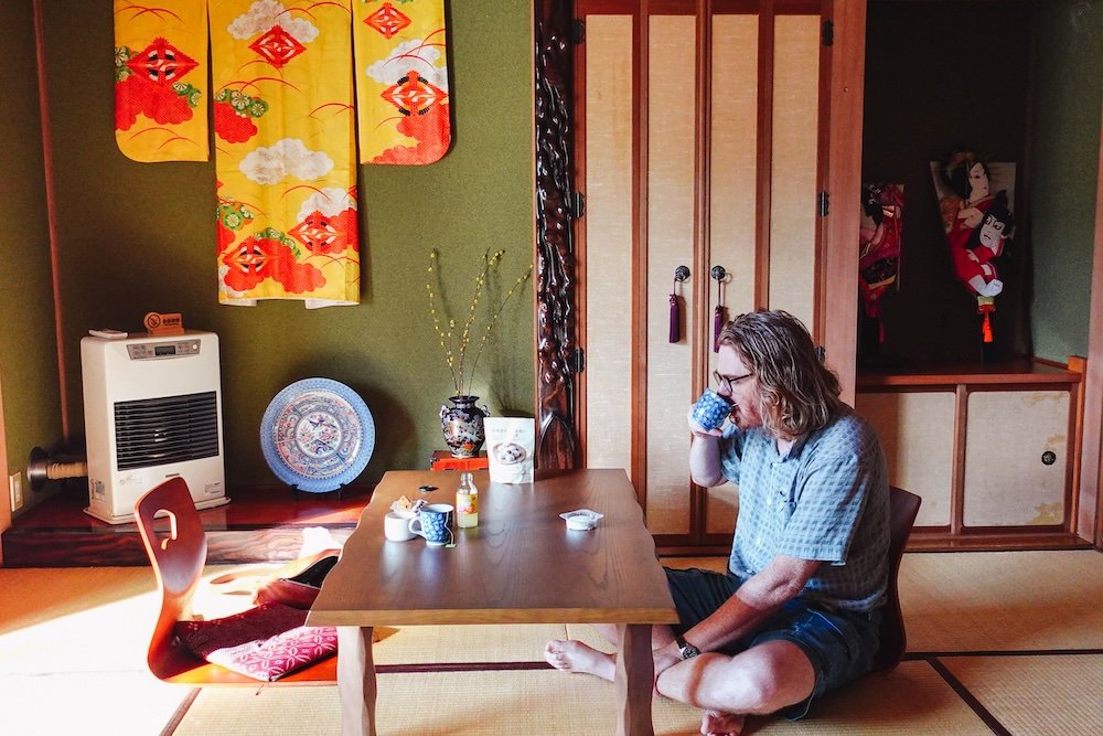 Nomadic Samuel enjoying Japanese tea at a local guesthouse in Japan 