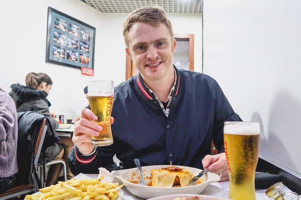 Nomadic Samuel enjoying local beer and cuisine in Porto, Portugal 