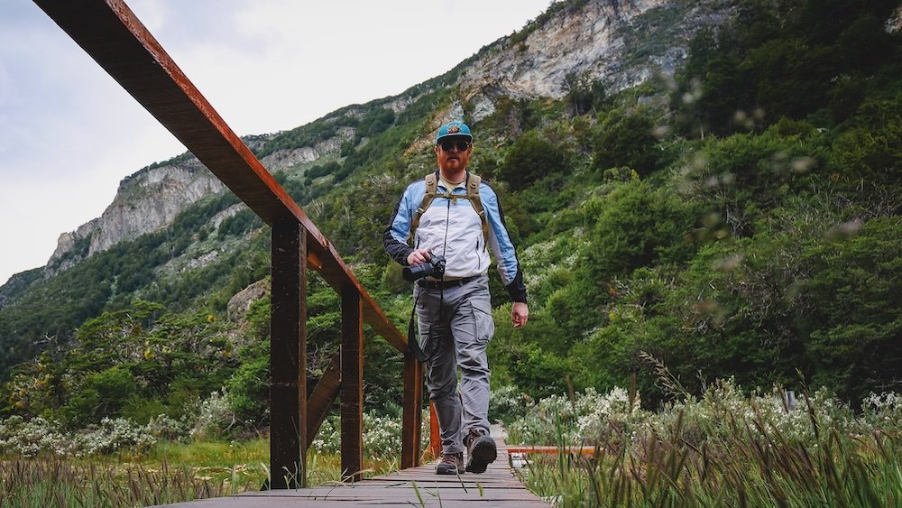 Nomadic Samuel hiking across a boardwalk in Tierra del Fuego National Park in Ushuaia, Argentina 