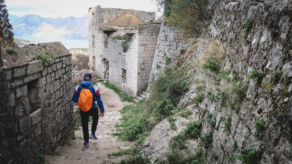 Nomadic Samuel hiking on a rustic trail in Kotor, Montenegro 