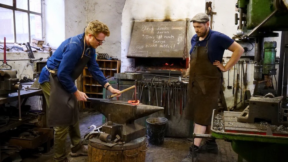 Nomadic Samuel in a forging workshop shaping metal into a piece of art in Saale-Unstrut