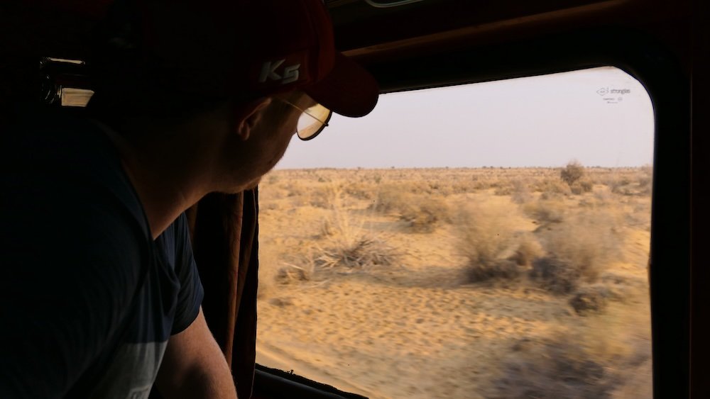 Nomadic Samuel looking out of the train window heading to Jodhpur, India 