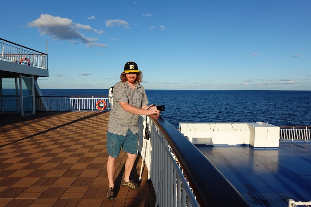 Nomadic Samuel on time to take photos of scenery on Japanese ferry 