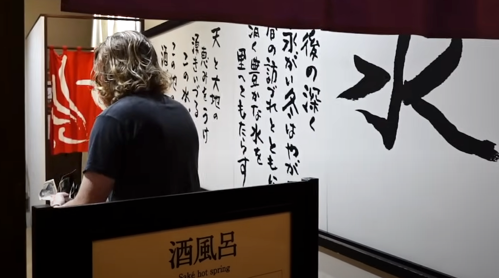 Nomadic Samuel paying to enter the Sake Onsen in Yuzawa, Japan 