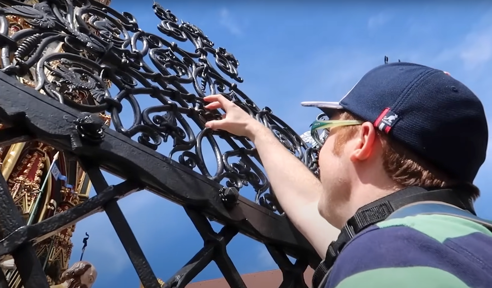 Nomadic Samuel reaching out to touch the Rings for Good Luck Nürnberg Schöner Brunnen in Nuremberg, Germany