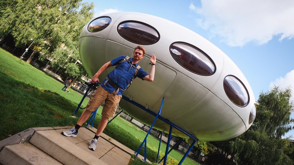 Nomadic Samuel standing next to the UFO Futuro Haus rare architectural oddity resembling a flying saucer in Werksviertel district near Ostbahnhof in Munich, Germany 