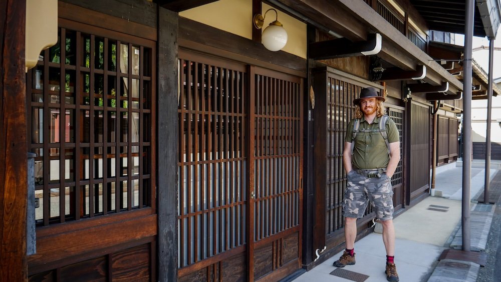 Nomadic Samuel standing outside traditional architecture in Takayama, Japan 