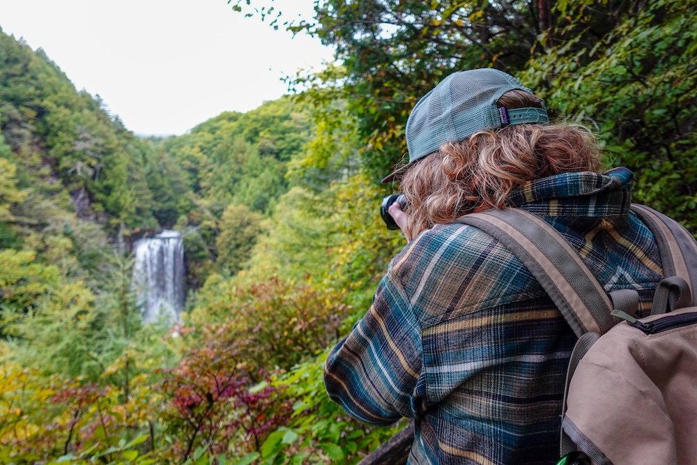 Nomadic Samuel taking photos of a stunning waterfall in Norikura Highlands in Nagano, Japan 