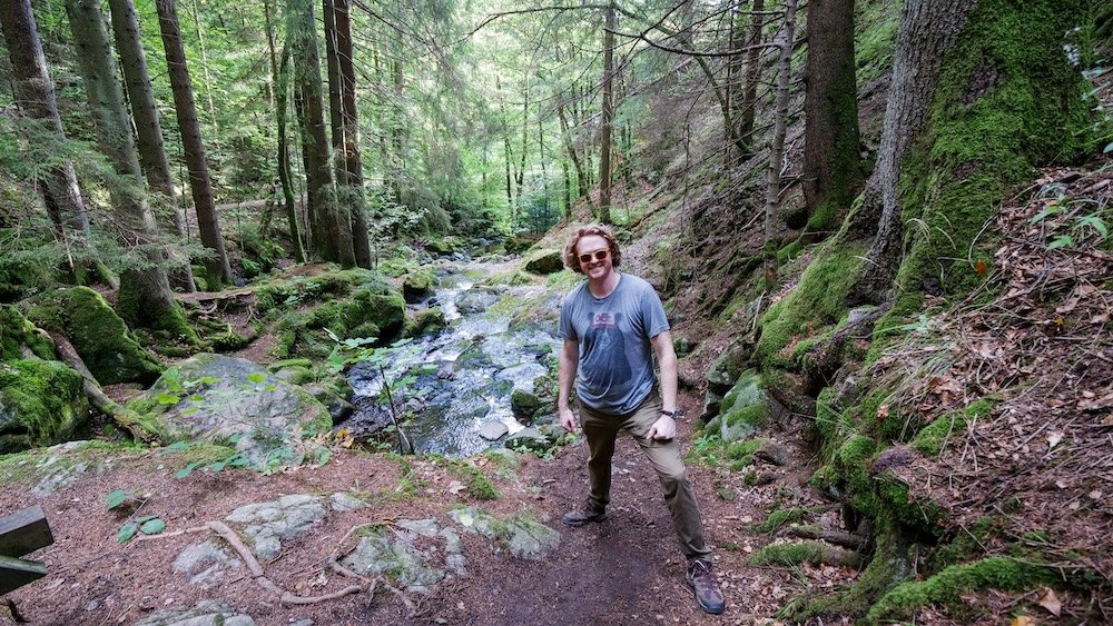 Nomadic Samuel thoroughly enjoying the Ravenna Gorge Hike known as Ravennaschlucht through a mossy ravine in the Black Forest, Germany