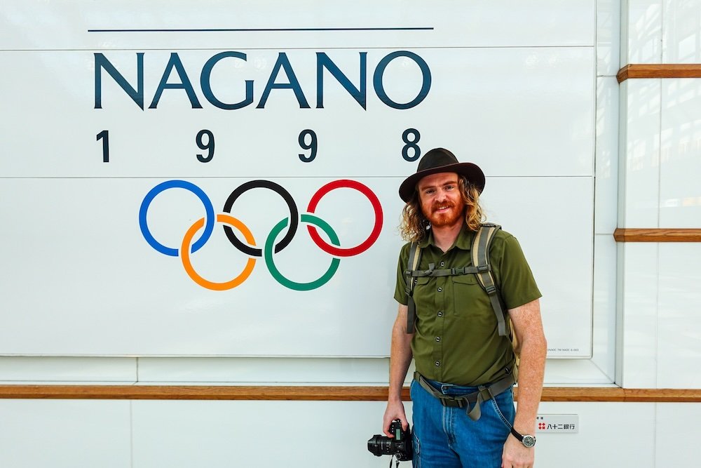 Nomadic Samuel thrilled to be visiting Nagano city, Japan standing outside the stadium that held the winter olympics in 1998 