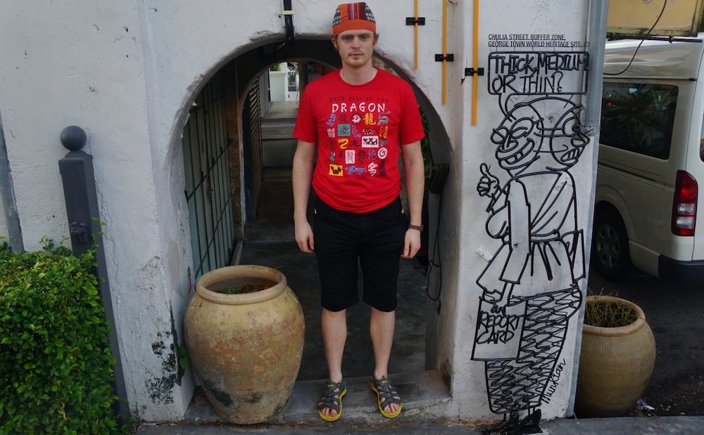 Nomadic Samuel too tall to walk under the archways of colonial architecture in George Town, Penang, Malaysia 