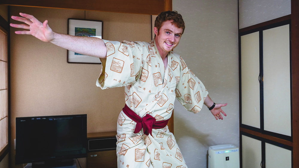 Nomadic Samuel wearing a traditional Japanese robe at a Ryokan in Japan