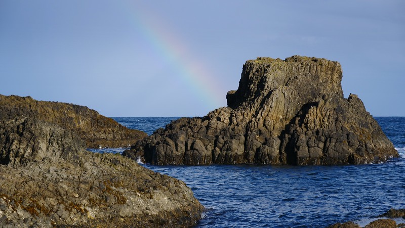 Northern Ireland Coastal Walk with rainbow views and rugged cliffs overlooking the water 