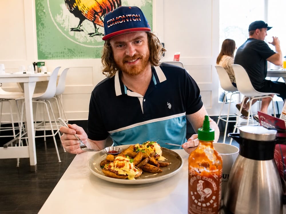 Samuel Jeffery at OEB Breakfast Co. in Downtown Edmonton, Alberta, Canada Samuel Jeffery sits inside OEB Breakfast Co. in downtown Edmonton, Alberta, Canada, with an eggs Benedict brunch plate, breakfast potatoes, hot sauce and coffee on the table.