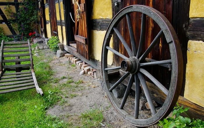 Open air museum with a rustic wagon wheel and doors in Spreewald, Germany