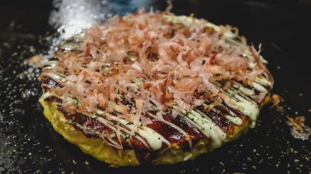 Osaka signature dish okonomiyaki a savory pancake packed with a variety of ingredients and topped with delicious sauces