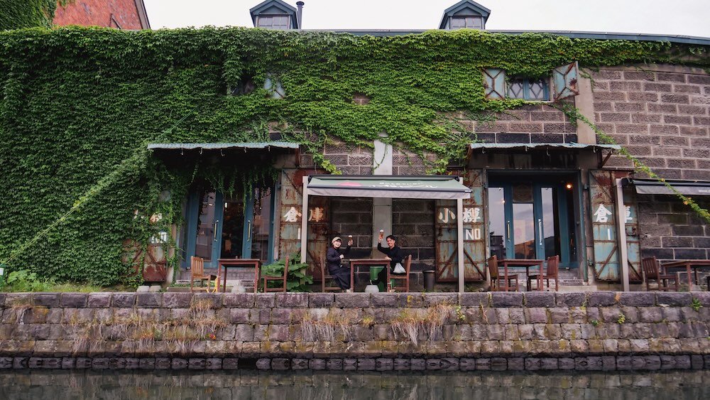 Otaru Beer Warehouse with happy beer drinkers raising a pint as we passed by them on our canal cruise in Japan 