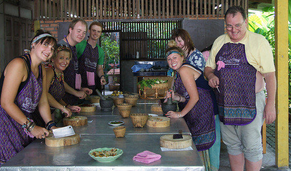 Our group shot - Thai cooking course - with us all adorning aprons of the one size fits all variety in Chiang Mai, Thailand