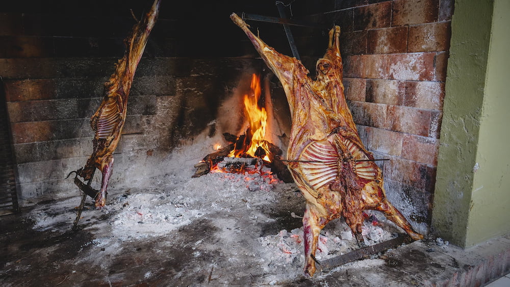 Patagonian lamb also known as Argentine cordero being cooked on an open fire