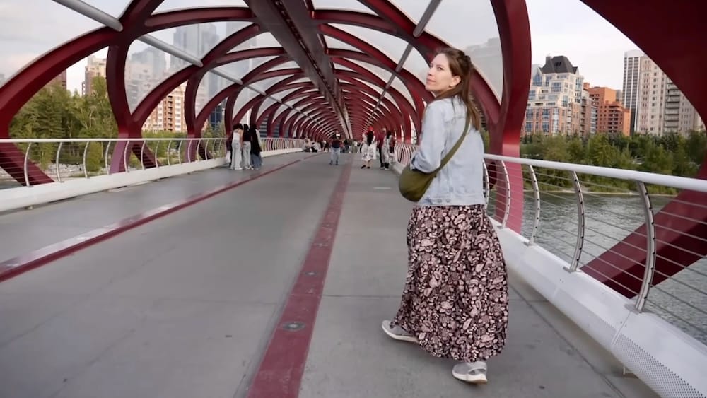 Audrey Bergner Walking Across the Peace Bridge, Calgary, Alberta, Canada Audrey Bergner looking back while walking through the iconic red and white tubular structure of the Peace Bridge over the Bow River in Calgary, Alberta, Canada.