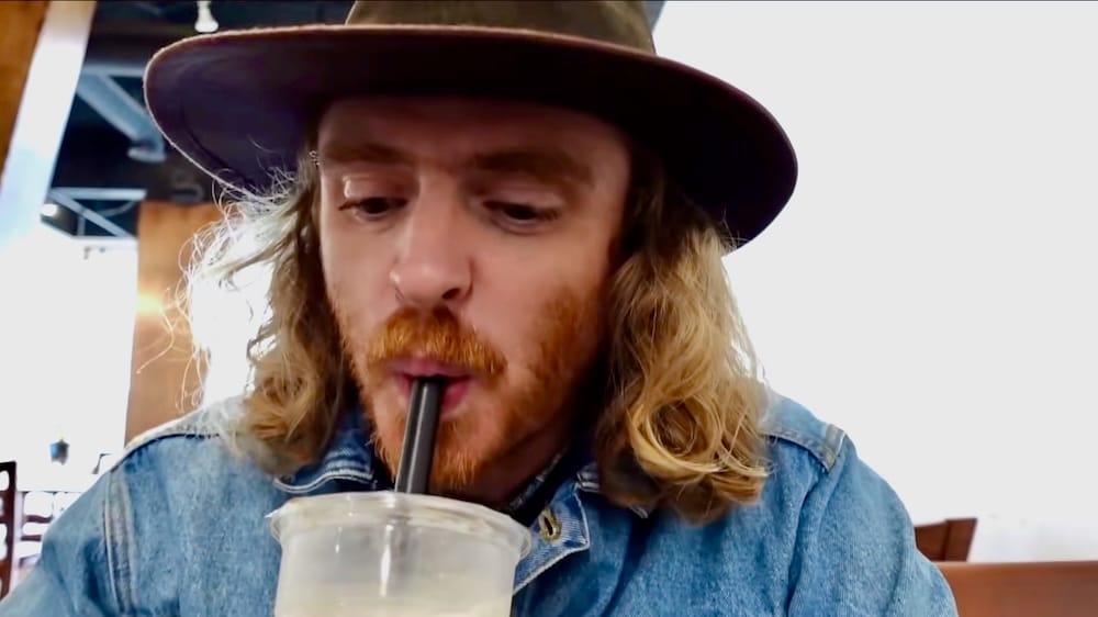 Samuel Jeffery drinks a coconut milk bubble tea through a straw at Peak Cafe in Banff, Alberta, Canada.