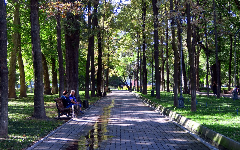 People sitting down on a park bench at Erkindik Park in Bishkek, Kyrgyzstan